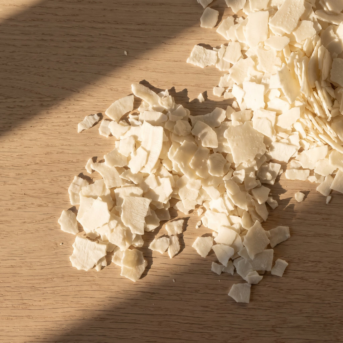 Soy and coconut wax flakes on a worktable for candle making